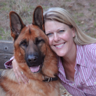 Woman smiling next to a German shepherd