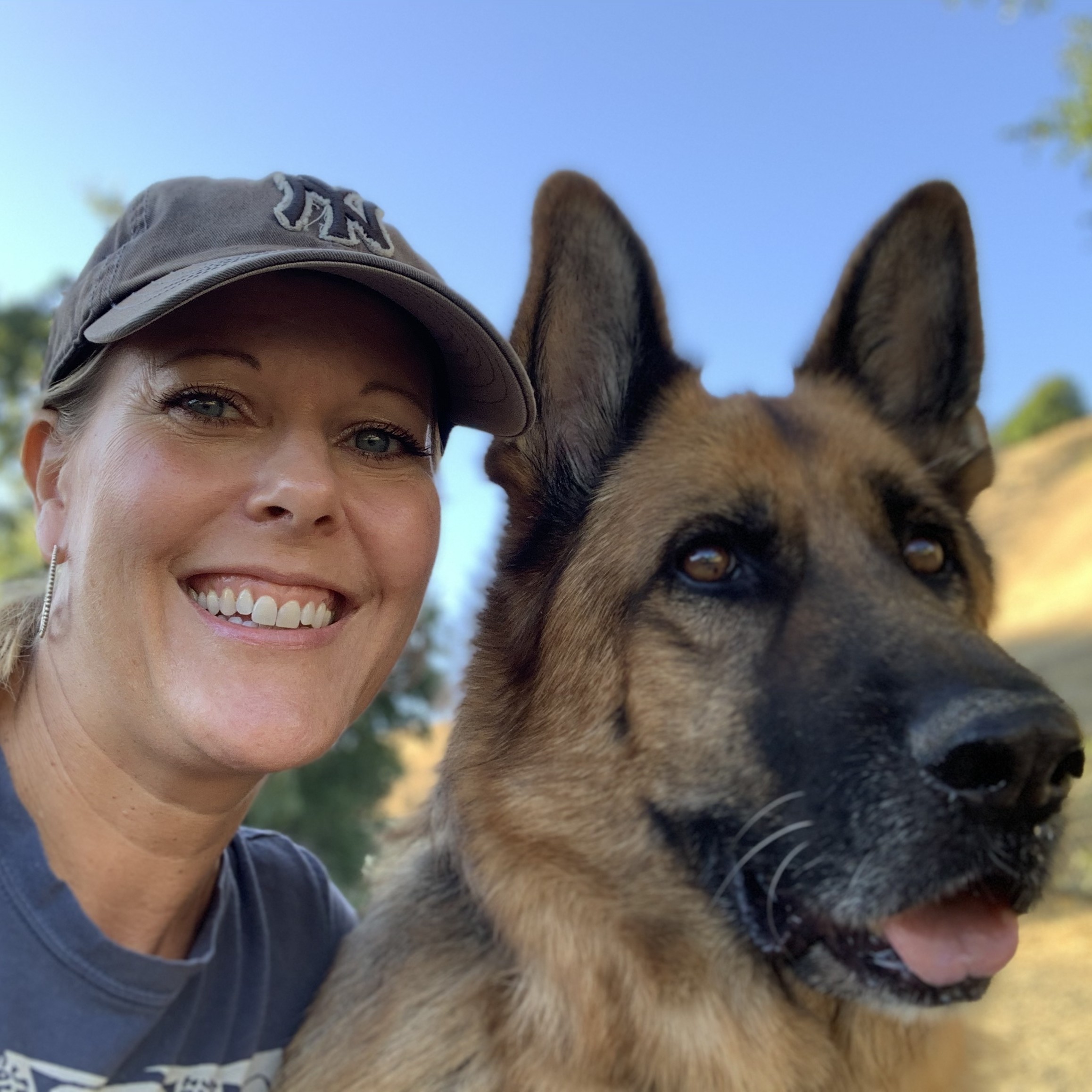a woman taking a selfie with a German Shepherd dog.